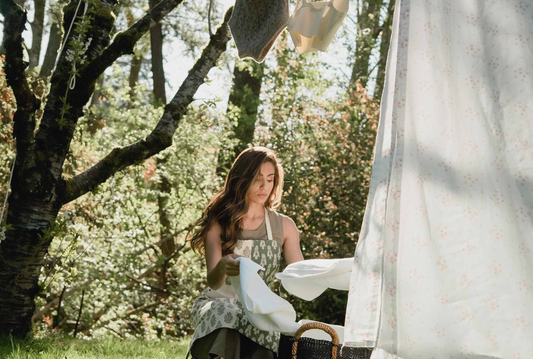 A Woman in Green Dress Folding Laundry