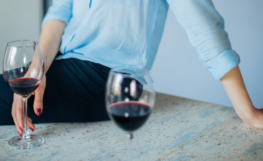 woman sitting on counter with red wine